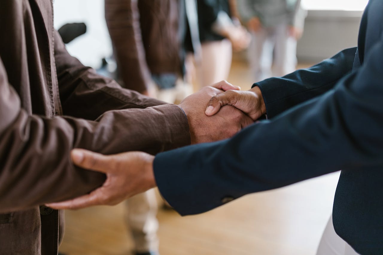 about-us Close-up of two businesspeople shaking hands, symbolizing agreement and partnership.